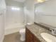 White tiled bathroom with a shower-tub combo and granite countertop vanity at 2577 Ozella Sw Pl, Atlanta, GA 30331