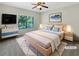 Bright, staged bedroom boasts a ceiling fan, a large window, and neutral decor at 2577 Ozella Sw Pl, Atlanta, GA 30331