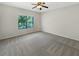 Neutral bedroom features a ceiling fan, large window, and plush carpet at 2577 Ozella Sw Pl, Atlanta, GA 30331