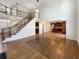 Open-concept living room with hardwood floors, elegant staircase and view into updated kitchen at 2577 Ozella Sw Pl, Atlanta, GA 30331