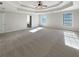 Expansive carpeted bedroom featuring a tray ceiling and natural light from two windows at 2577 Ozella Sw Pl, Atlanta, GA 30331