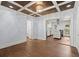 Living room featuring hardwood floors, coffered ceiling with chandelier, and open access to the modern kitchen at 1686 Alvarado Sw Ter, Atlanta, GA 30310