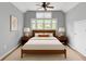 Staged bedroom with neutral color palette, ceiling fan, and warm wood accents at 3111 Jones St, East Point, GA 30344