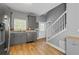 Charming kitchen features gray cabinets, stainless steel appliances, and hardwood floors, complementing the staircase at 3111 Jones St, East Point, GA 30344