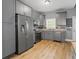 Modern kitchen features stainless steel appliances, gray cabinets, hardwood floors and great light at 3111 Jones St, East Point, GA 30344