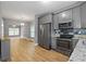 Bright kitchen with gray cabinets, stainless steel appliances, and adjacent living area for easy entertaining at 3111 Jones St, East Point, GA 30344