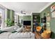This modern living room showcases a green accent wall, stylish furniture, plants and a large window at 57 Forsyth Nw St # 11G, Atlanta, GA 30303