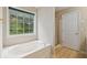 Bathroom featuring a jacuzzi tub, shower, and large window providing natural light at 111 Trellis Ct, Acworth, GA 30101