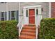 Inviting front entrance with brick steps, red door, and manicured hedges at 111 Trellis Ct, Acworth, GA 30101