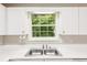 Bright kitchen with stainless steel sink and modern fixtures under window at 111 Trellis Ct, Acworth, GA 30101