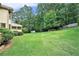 Expansive backyard featuring lush lawn, mature trees, landscaping, and storage shed at 3641 Mountain Cove Rd, Snellville, GA 30039