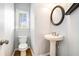 Charming half bathroom with a pedestal sink, wood floors, and modern fixtures at 3641 Mountain Cove Rd, Snellville, GA 30039