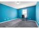 Bedroom featuring blue painted walls, carpeted floor, a desk, and a window at 3641 Mountain Cove Rd, Snellville, GA 30039