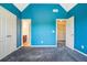 Well-lit bedroom with blue walls, gray carpet and two closets with white double doors at 3641 Mountain Cove Rd, Snellville, GA 30039