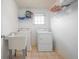 Functional laundry room with washer, dryer, sink, window, tile floor and shelving at 3641 Mountain Cove Rd, Snellville, GA 30039