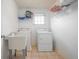 Functional laundry room with sink, washer, dryer and convenient shelving for storage at 3641 Mountain Cove Rd, Snellville, GA 30039
