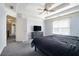 Spacious main bedroom featuring a tray ceiling, ceiling fan, and cozy carpet at 3641 Mountain Cove Rd, Snellville, GA 30039