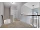 Upstairs hallway features neutral walls, neutral carpet, and a modern railing with an open view to below at 4251 Haywater Cv, Buford, GA 30519