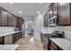 Modern kitchen features stainless steel appliances, white countertops, and dark wood cabinets at 4251 Haywater Cv, Buford, GA 30519