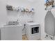 Conveniently located laundry room features a modern washer and dryer, shelf storage and an ironing board at 4251 Haywater Cv, Buford, GA 30519