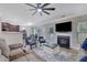 Open living area with hardwood floors, fireplace, ceiling fan, and access to other rooms at 4251 Haywater Cv, Buford, GA 30519