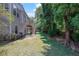 Expansive backyard with lush lawn, mature trees, and wooden deck stairs, perfect for outdoor living at 590 Kyle Trace Ct, Sugar Hill, GA 30518