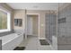 A modern bathroom with tiled shower, soaking tub, and large window at 590 Kyle Trace Ct, Sugar Hill, GA 30518