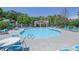 Resort-style community pool with ample seating, a clubhouse, and a playground in the background at 590 Kyle Trace Ct, Sugar Hill, GA 30518