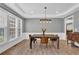 Dining room with hardwood floors, wainscoting, large windows, and a stylish light fixture at 590 Kyle Trace Ct, Sugar Hill, GA 30518
