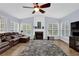 Spacious living room featuring a fireplace, ceiling fan, and abundant natural light at 590 Kyle Trace Ct, Sugar Hill, GA 30518