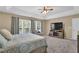Bright main bedroom featuring a large window, ceiling fan and media console at 590 Kyle Trace Ct, Sugar Hill, GA 30518