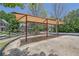 Shaded swing set with picnic tables, offering a comfortable and relaxing outdoor recreation area at 590 Kyle Trace Ct, Sugar Hill, GA 30518