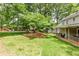 Lush backyard featuring expansive green space, mature trees, and covered porch at 1404 Vernon North Dr, Dunwoody, GA 30338