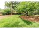 Large, lush backyard with mature trees, green grass, and a wooded fence at 1404 Vernon North Dr, Dunwoody, GA 30338