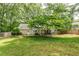 Spacious backyard with lush green grass, mature trees, and a wooden fence for privacy at 1404 Vernon North Dr, Dunwoody, GA 30338