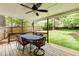 Covered porch with ceiling fan and outdoor seating overlooks fenced backyard at 1404 Vernon North Dr, Dunwoody, GA 30338