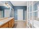 Bright bathroom features a double vanity, tile flooring, shower, bathtub, and framed glass door to another room at 239 Berry Rd, Mcdonough, GA 30252