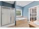 Bathroom with separate shower, soaking tub, tiled surround, vanity, window, and framed glass door at 239 Berry Rd, Mcdonough, GA 30252