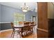 Elegant dining room boasts natural light, wood flooring, a classic chandelier, and seating for six around a wood table at 239 Berry Rd, Mcdonough, GA 30252