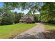 Well-maintained home with a long driveway, beautiful lawn, and mature trees at 239 Berry Rd, Mcdonough, GA 30252