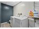 Bright laundry room featuring a washer, dryer, and shelving for storage and organization at 239 Berry Rd, Mcdonough, GA 30252