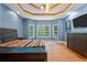 Bright main bedroom with bay windows, tray ceiling, and warm wood flooring at 239 Berry Rd, Mcdonough, GA 30252