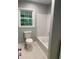 Bright bathroom featuring a white bathtub with shower and modern toilet at 2934 Union Grove Rd, Conyers, GA 30012