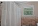 Tile shower with a white curtain and window at 648 Cativo Sw Dr, Atlanta, GA 30311