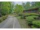Long driveway leading to charming brick home with mature landscaping and lush greenery at 648 Cativo Sw Dr, Atlanta, GA 30311