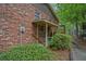 Side view of charming brick home with covered porch and lush landscaping for added privacy at 648 Cativo Sw Dr, Atlanta, GA 30311