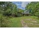 Charming ranch-style home surrounded by lush greenery and trees with a stone pathway in the front yard at 648 Cativo Sw Dr, Atlanta, GA 30311