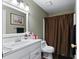 Neutral bathroom featuring a single sink vanity, framed mirror, and a shower with a brown shower curtain at 1377 Downington Nw Ln, Acworth, GA 30101