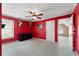 Bedroom with red walls, white trim, ceiling fan, and open door to the next room at 1377 Downington Nw Ln, Acworth, GA 30101