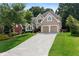 Two-story home with a well-manicured lawn, attached two-car garage, and a spacious driveway at 1377 Downington Nw Ln, Acworth, GA 30101